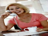 Smiling woman on phone with cup of coffee