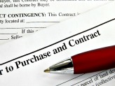Pen lying on top of purchase contract papers