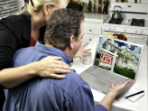 Man and woman on laptop looking at house for sale online