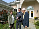 Realtor going over paperwork with couple outside home